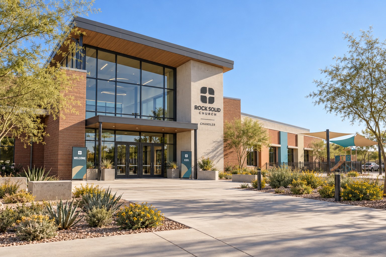 Chandler's contemporary family campus, with a tall glass entrance, sloping roof, kids wing, and shaded play courtyard.