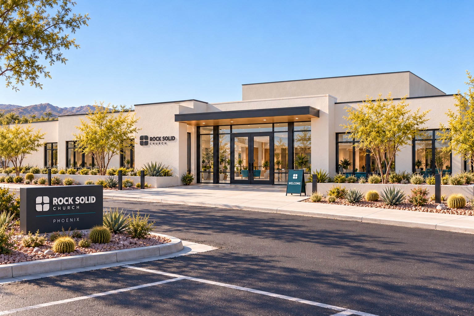 Phoenix's contemporary warm-white main campus, with its established glass lobby, charcoal canopy, desert garden, and Sunday welcome sign.